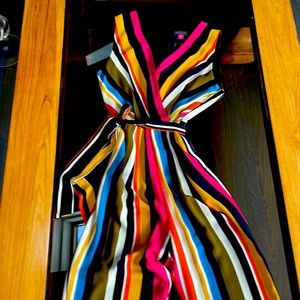 Gorgeous multi colored jump suit with zipper in the back, low cut front, belt